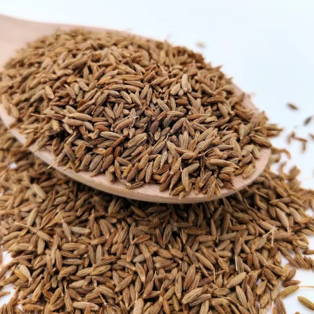 Kreuzkümmelsamen auf einem Holzlöffel