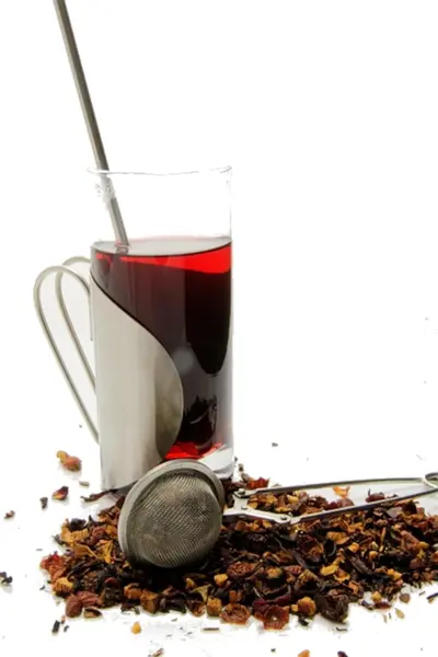 Früchtetee rot im Glas und lose mit Teesieb